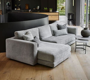 Moderne lysegrå L-formet sofa med højre chaiselong i stilfuldt rum.